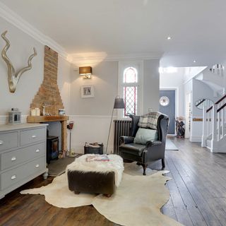 entrance hall with white wall and wooden flooring with black chair