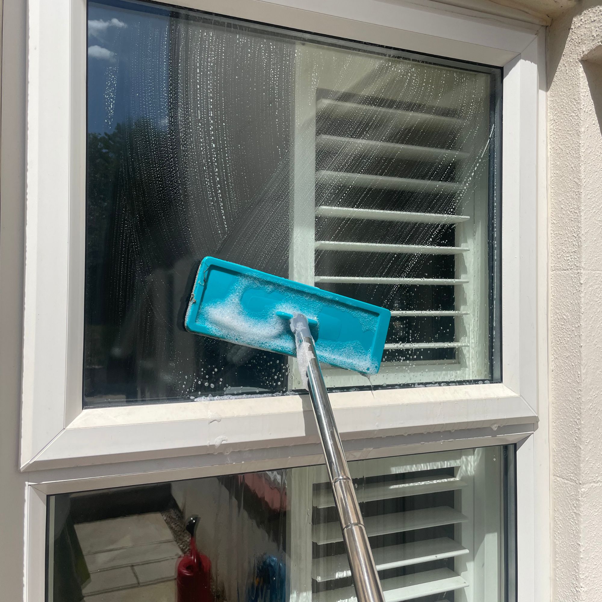 Using a blue mop to clean windows