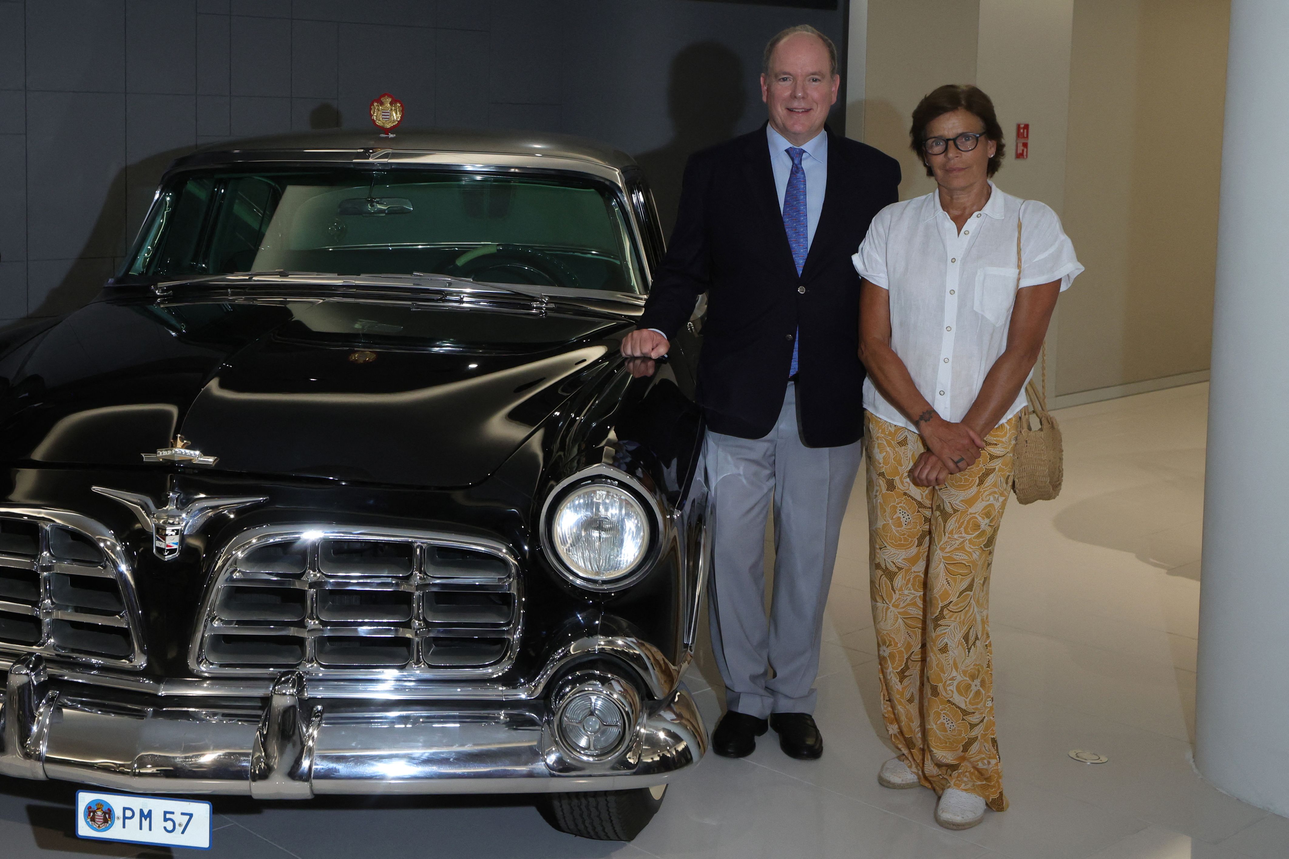 Prince Albert II of Monaco (L) and Princess Stephanie of Monaco pose with Chrysler Imperial 1956, the wedding car of Prince Rainier and Grace Kelly