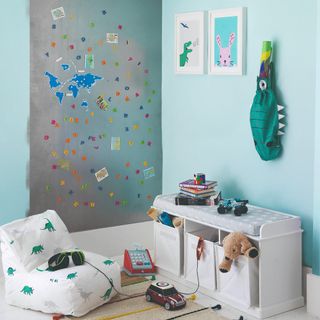 A playroom with a magnetic board and toy storage