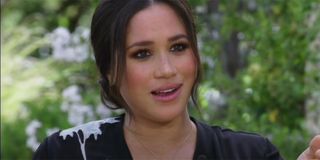 Meghan Markle sitting in a chair speaking to Oprah Winfrey during an interview.