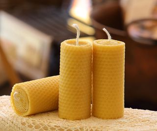 Three beeswax candles on a surface