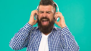 Loudest headphones: Man with beard listening to loud music on his headphones
