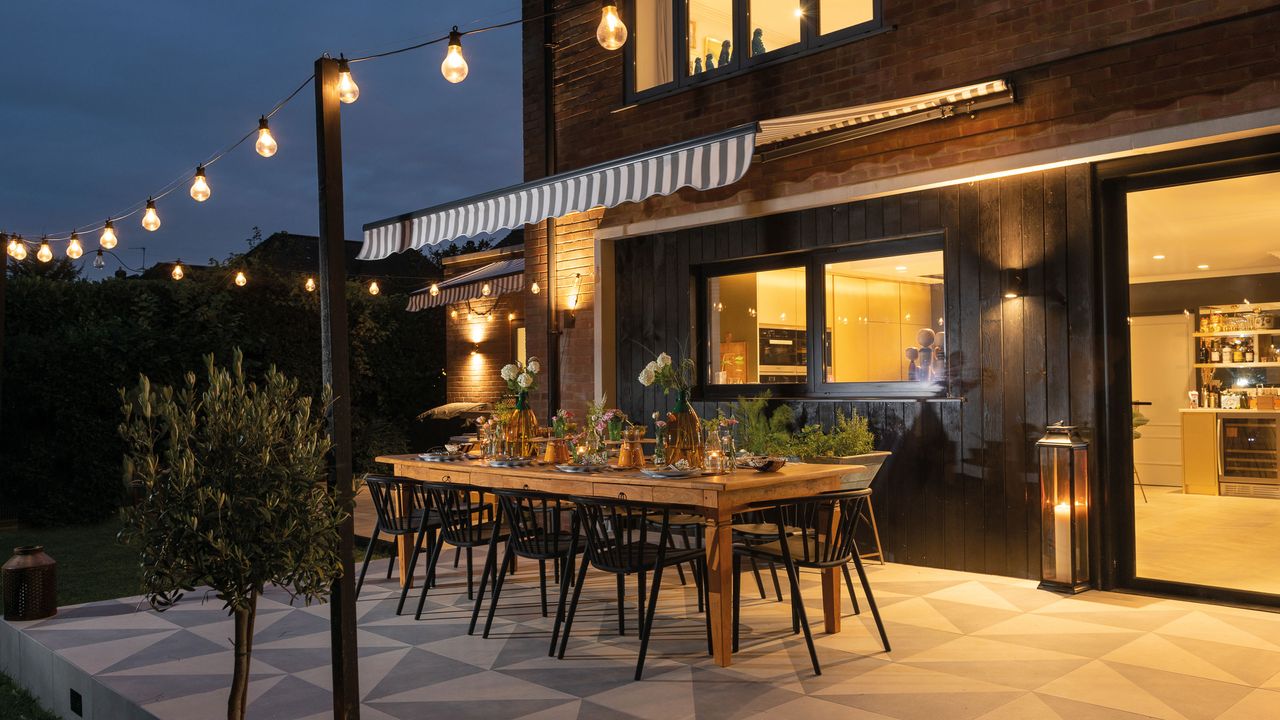 outdoor living space with festoon lighting and dining table