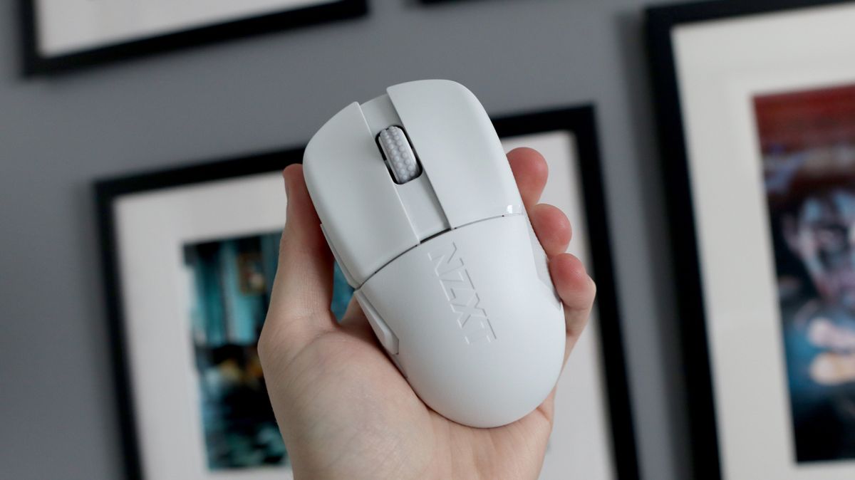 An NZXT Lift Elite Wireless gaming mouse in white set-up on a desk.