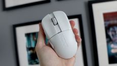 An NZXT Lift Elite Wireless gaming mouse in white set-up on a desk.