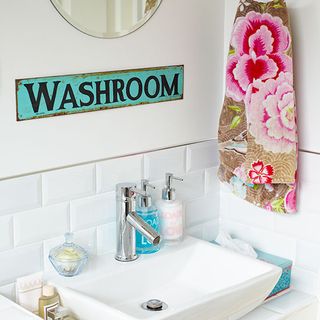 bathroom with vintage sign and floral towel