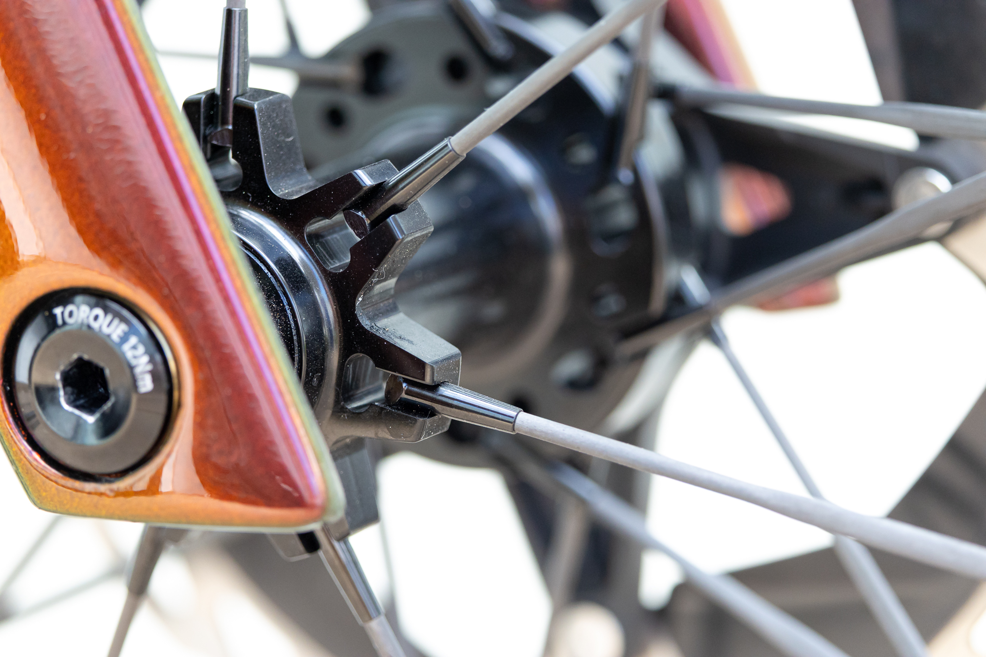 close up of a black front hub showing the T-head nipples and straight pull carbon spokes