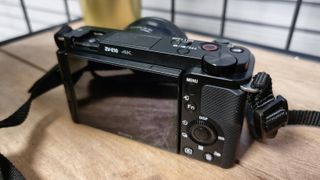 A shot of the back of the Sony ZV-E10 camera on a wooden desk