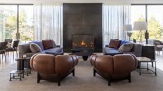 living room with brown leather sofas in front of fireplace with brown carpet