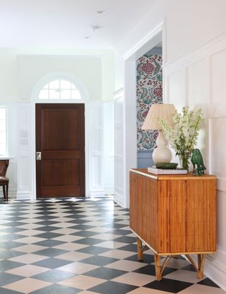 White entryway with patterned tiles and console
