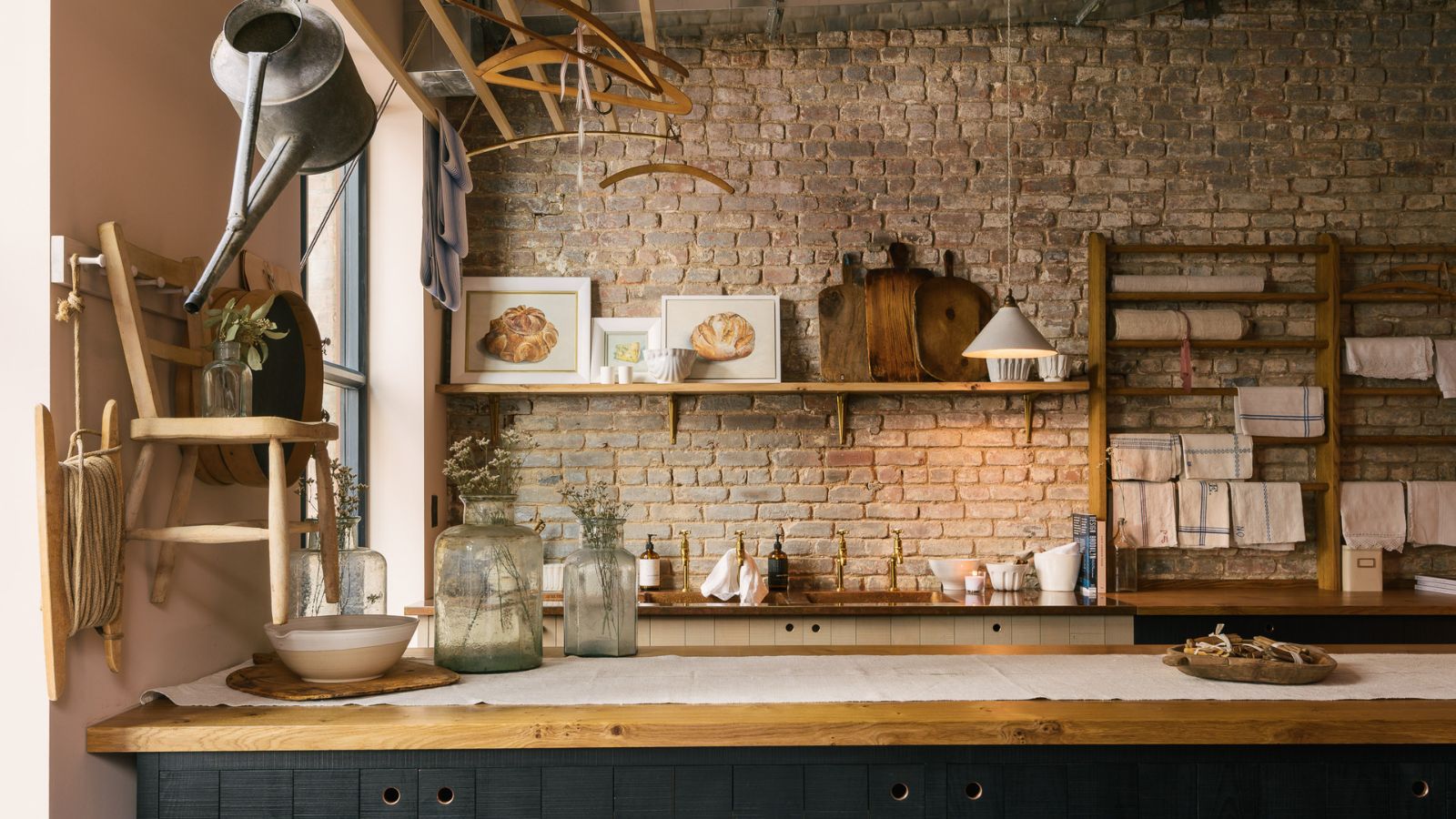 A Manhattan kitchen with an exposed stone wall, wooden countertops, and blue paneled cabinets