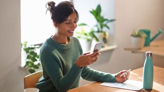 Woman researching whether you can still get pregnant during perimenopause on phone