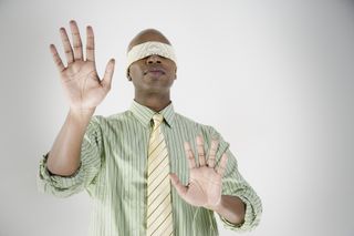 Businessman blindfolded with hands out