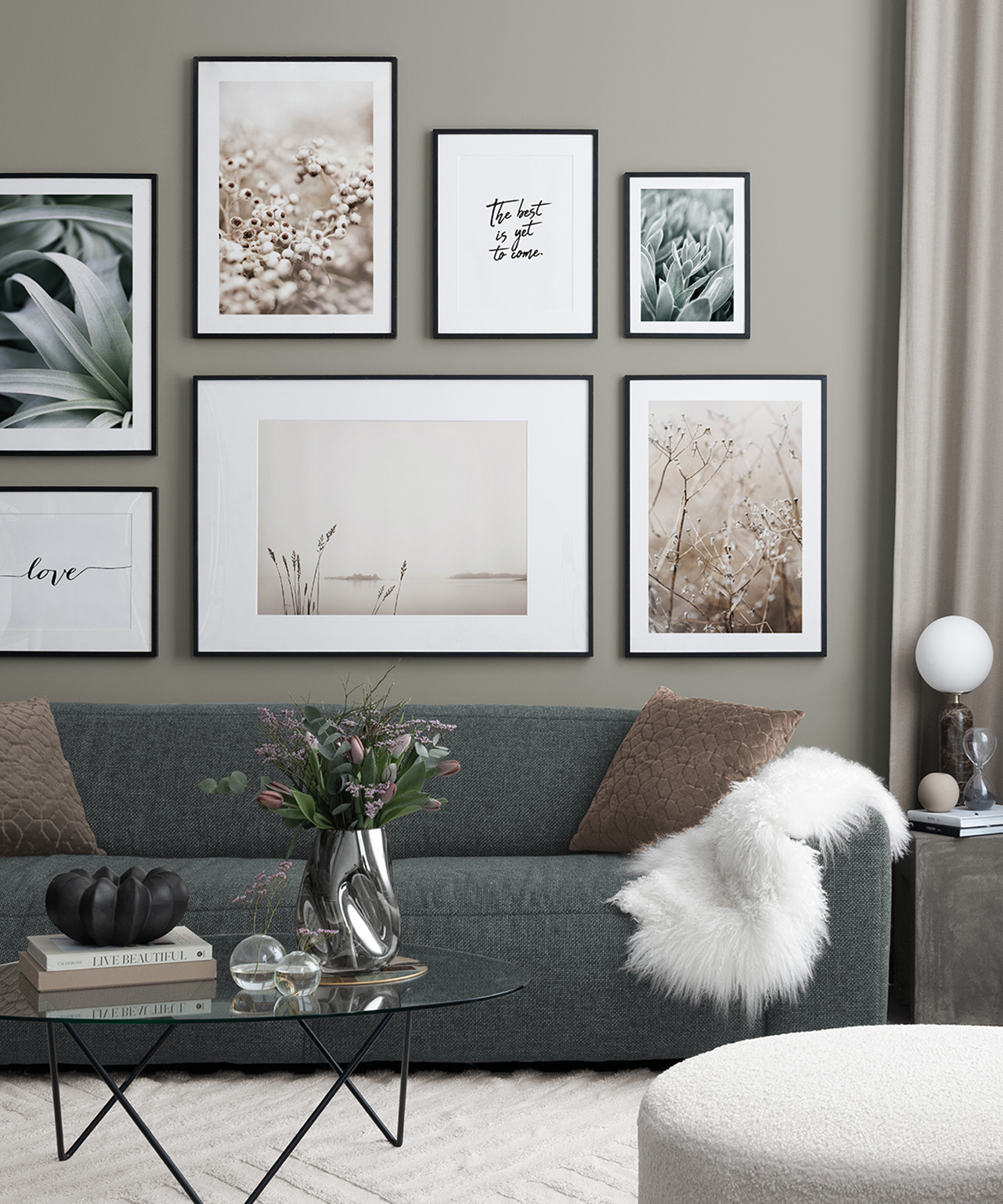 A grey living room with grey sofa and gallery wall with posters from Desenio