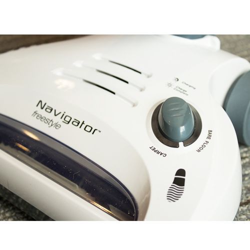 The Shark Navigator carpet-to-hardwood button is controlled with a button on the vacuum's head. You activate this button by pushing down on it with your foot.