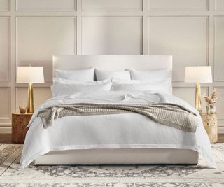 Boll & Branch Signature Hemmed Duvet Set on a bed against a cream wall.