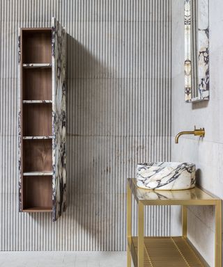 modern bathroom with tiled floors and walls, gold effect vanity with marble sink, marble and wood wall mounted storage