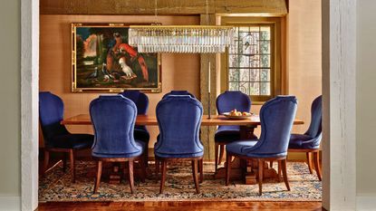 dining room with blue velvet chairs and silk wallcovering vintage rug