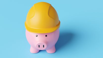 A piggy bank wears a hard hat.