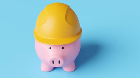 A piggy bank wears a hard hat.