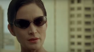 Carrie-Anne Moss stares ahead with concern in The Matrix.