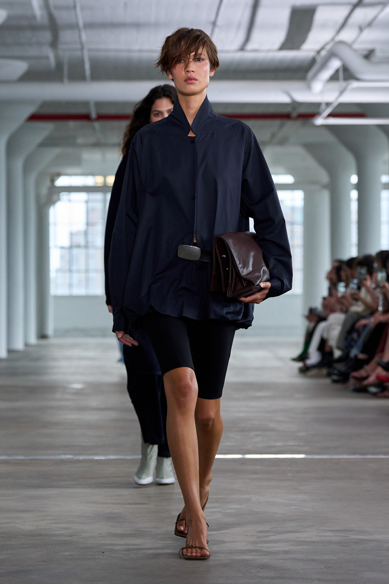 a woman wearing a navy windbreaker and black capris at at Tibi Spring 2025 show