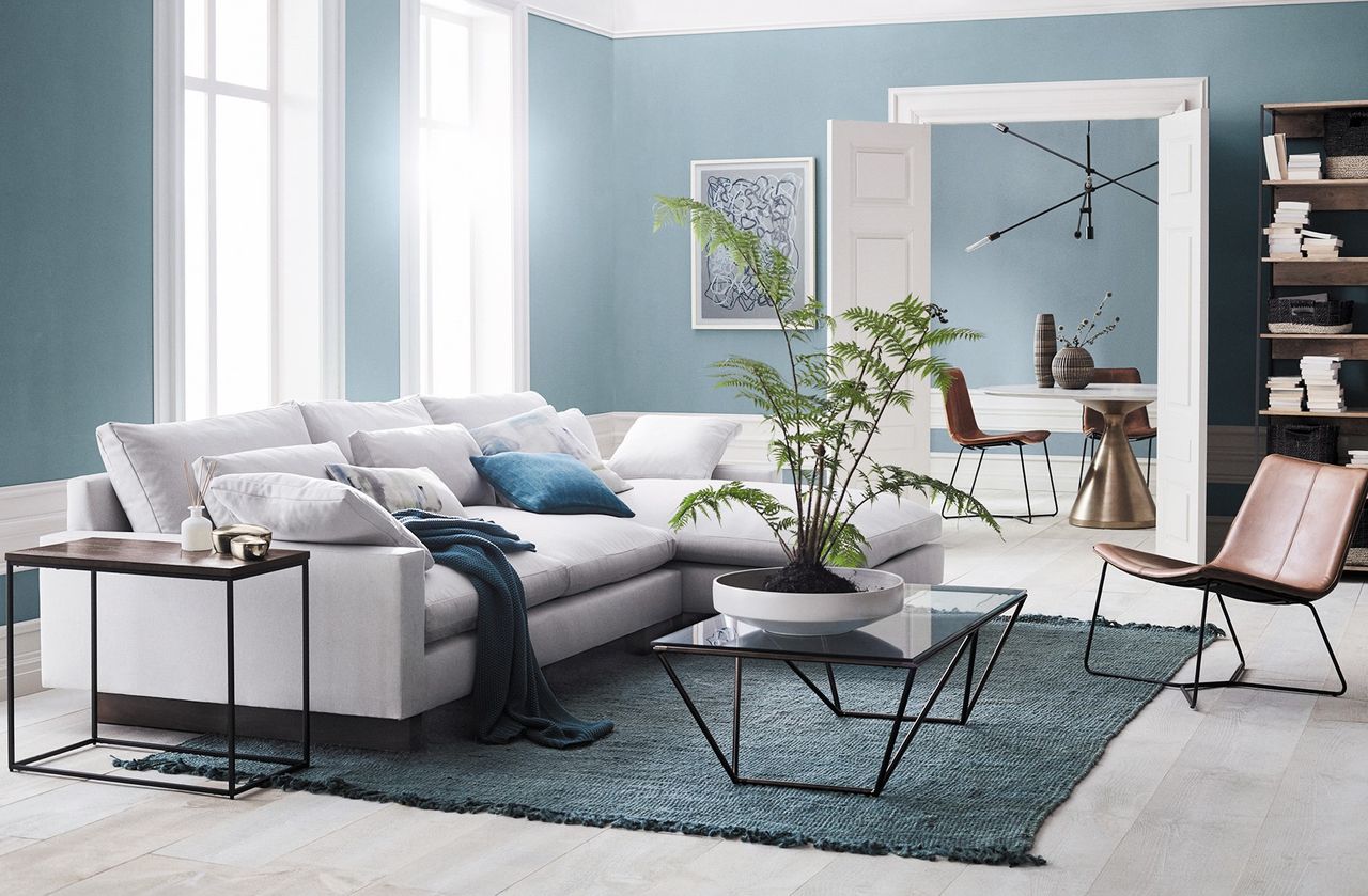 A living room with blue walls painted in Sherwin-Williams&#039; Debonair