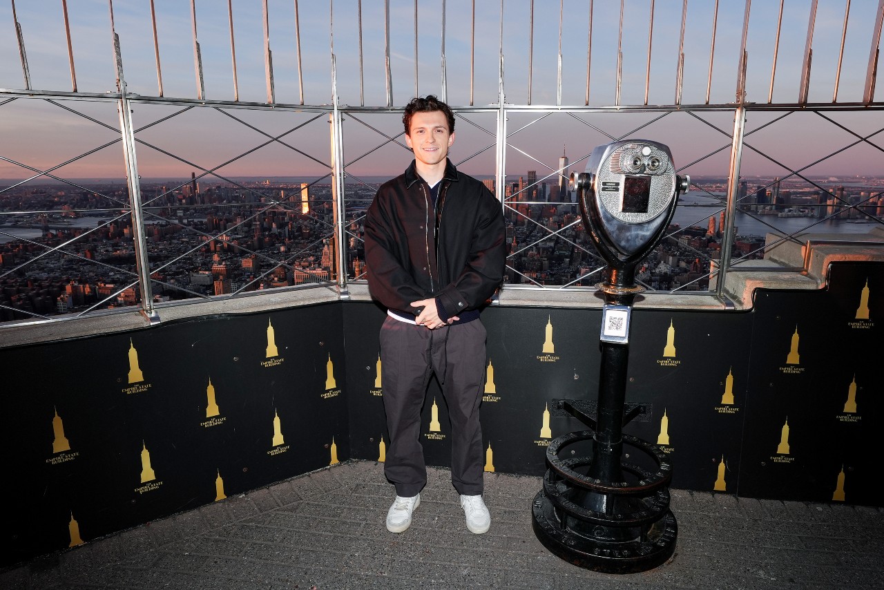 Tom Holland lights The Empire State Building on March 18, 2026 in New York City. He's standing at the top of the Empire State Building with his hands placed in front of him.
