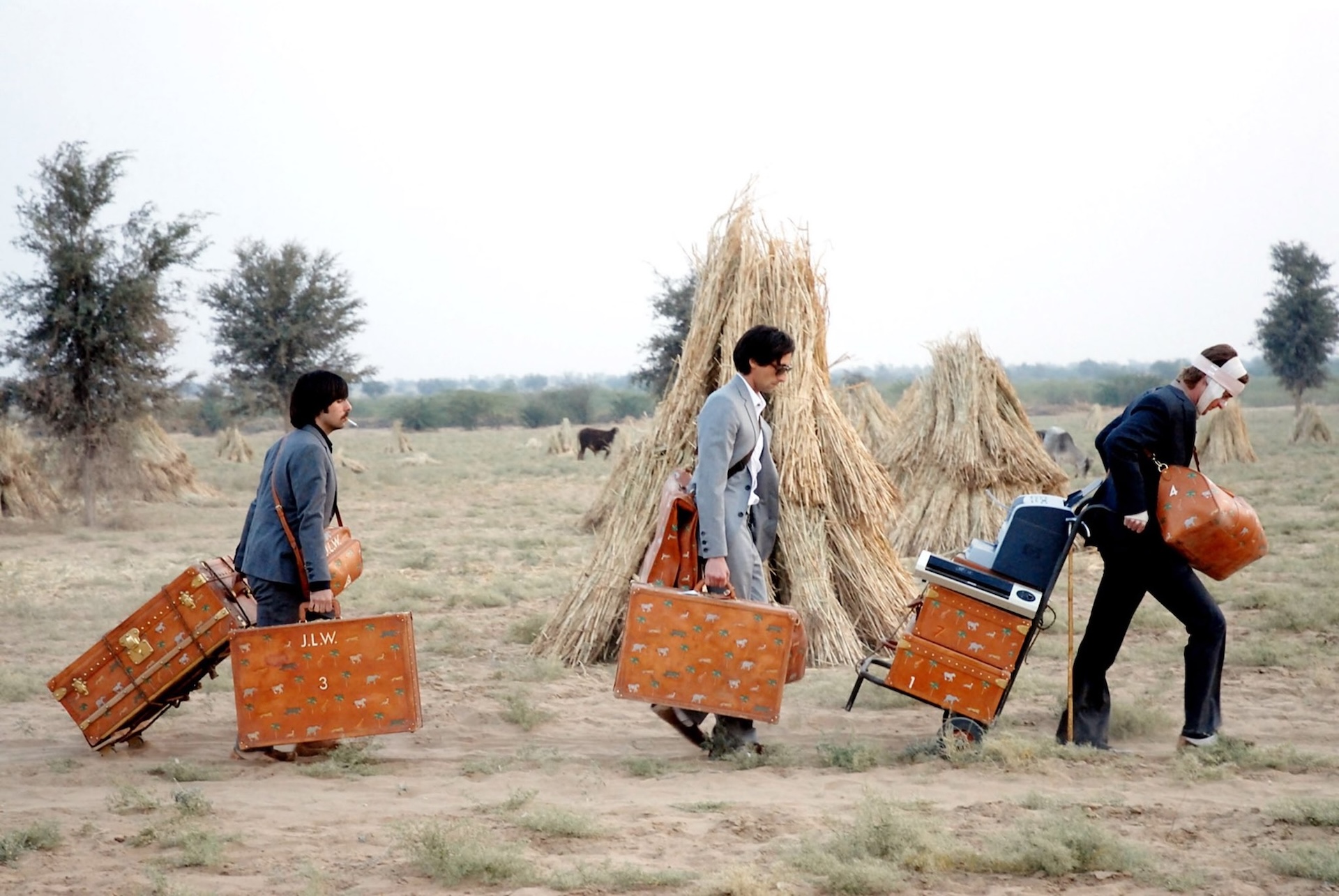 The Whitman brothers walking in The Darjeeling Limited carrying luggage