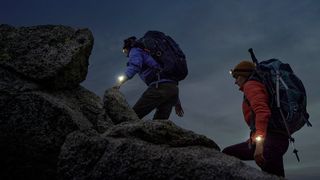 Two people hiking at night with Garmin Epix (Gen 2) Pro watches
