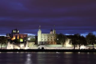 The Tower of London on the Thames River, at night.