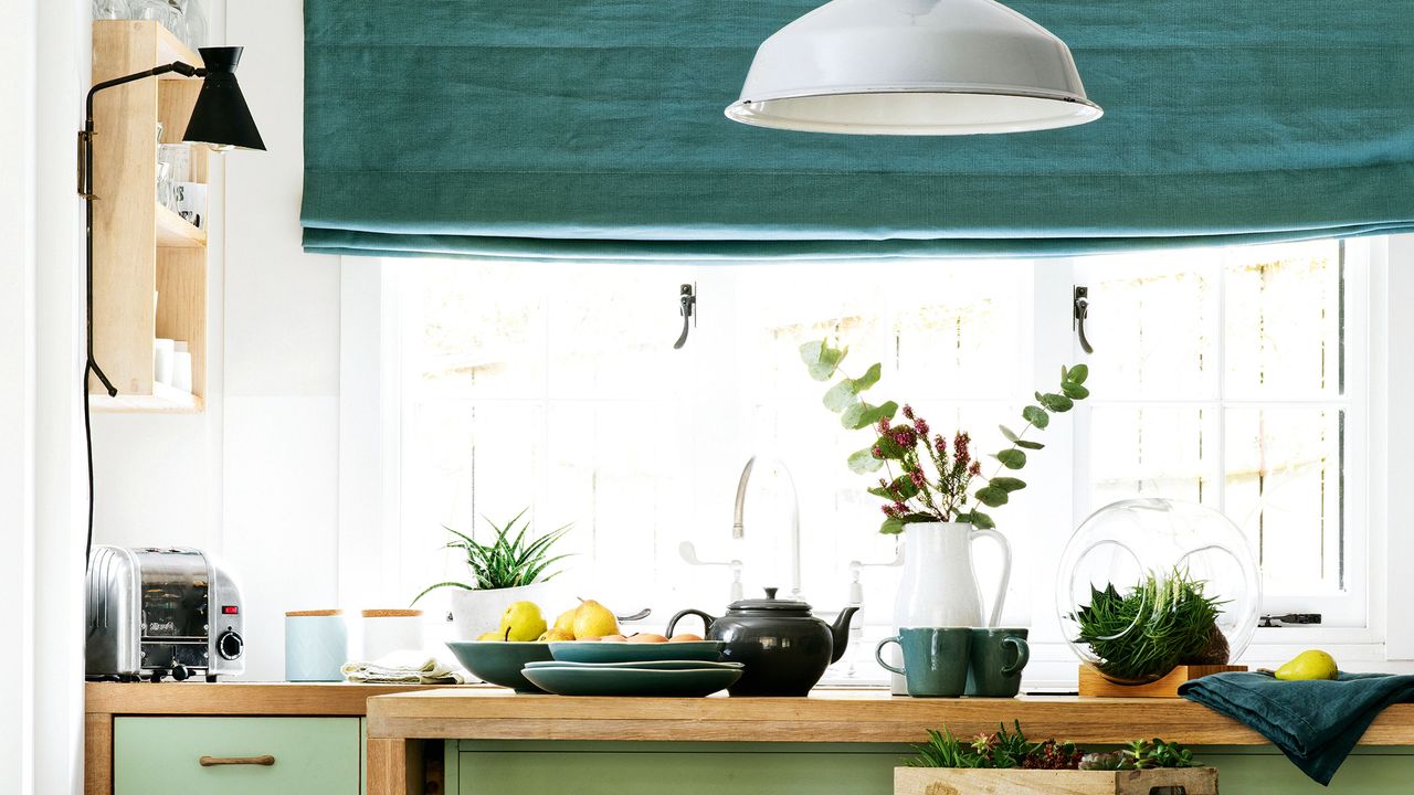 Teal blind in white kitchen with wooden island