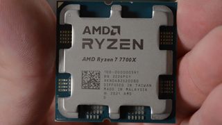 An AMD Ryzen 7 7700X in a man's hand