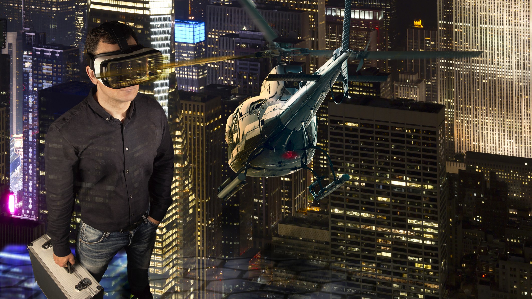 A man wearing a VR headsets stands in a virtual environment of skyscrapers and helicopters.