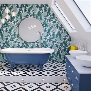 quirky bathroom with geometric black and white floor tiles, a blue roll top bath and vanity unit, foliage green wallpaper on one wall, and a circular wall mirror