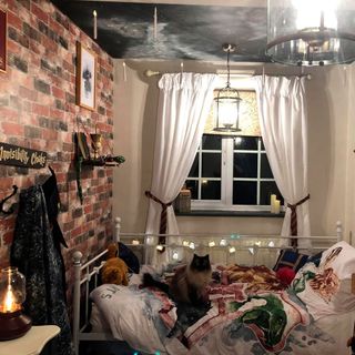 bedroom with harry porter themed curtains and brick walls