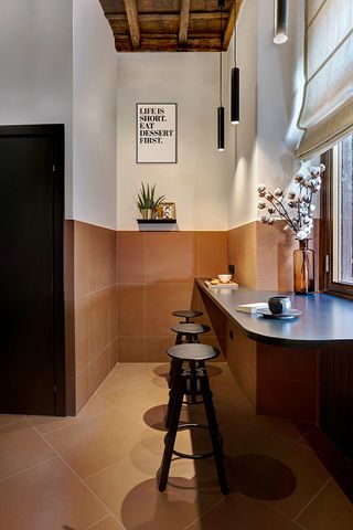 Alternative view of Francesca Venturoni's kitchen area featuring bar table, matching stools and black cylinder pendant lights