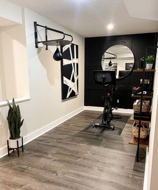 home gym with wood flooring, exercise bike and gym mirror - Colleen Walsh