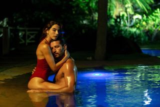 GIOVANNA LANCELLOTTI as BABI, LEANDRO LIMA as MARCO embracing in a swimming pool in Burning Betrayal