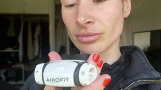 Writer Sam holding the Airofit RMT breathing device during testing
