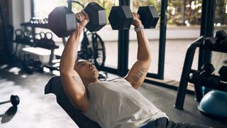 Man performs incline dumbbell bench press