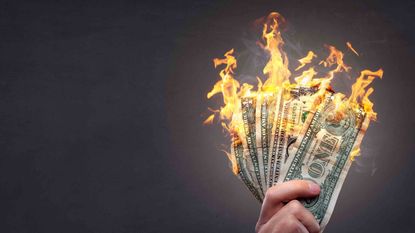 person holding dollar bills that are on fire