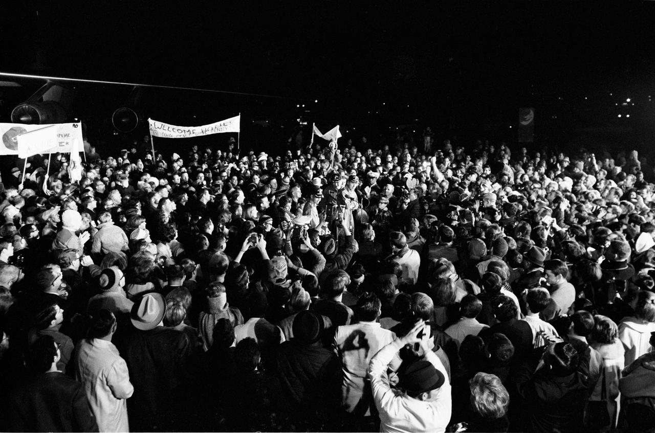 Although it was past 2 a.m., a crew of more than 2,000 people were on hand at Ellington Air Force Base to welcome the members of the Apollo 8 crew back home. Astronauts Frank Borman, James A. Lovell Jr., and William A. Anders had just flown to Houston from the pacific recovery area by way of Hawaii. The three crewmen of the historic Apollo 8 lunar orbit mission are standing at the microphones in center of picture