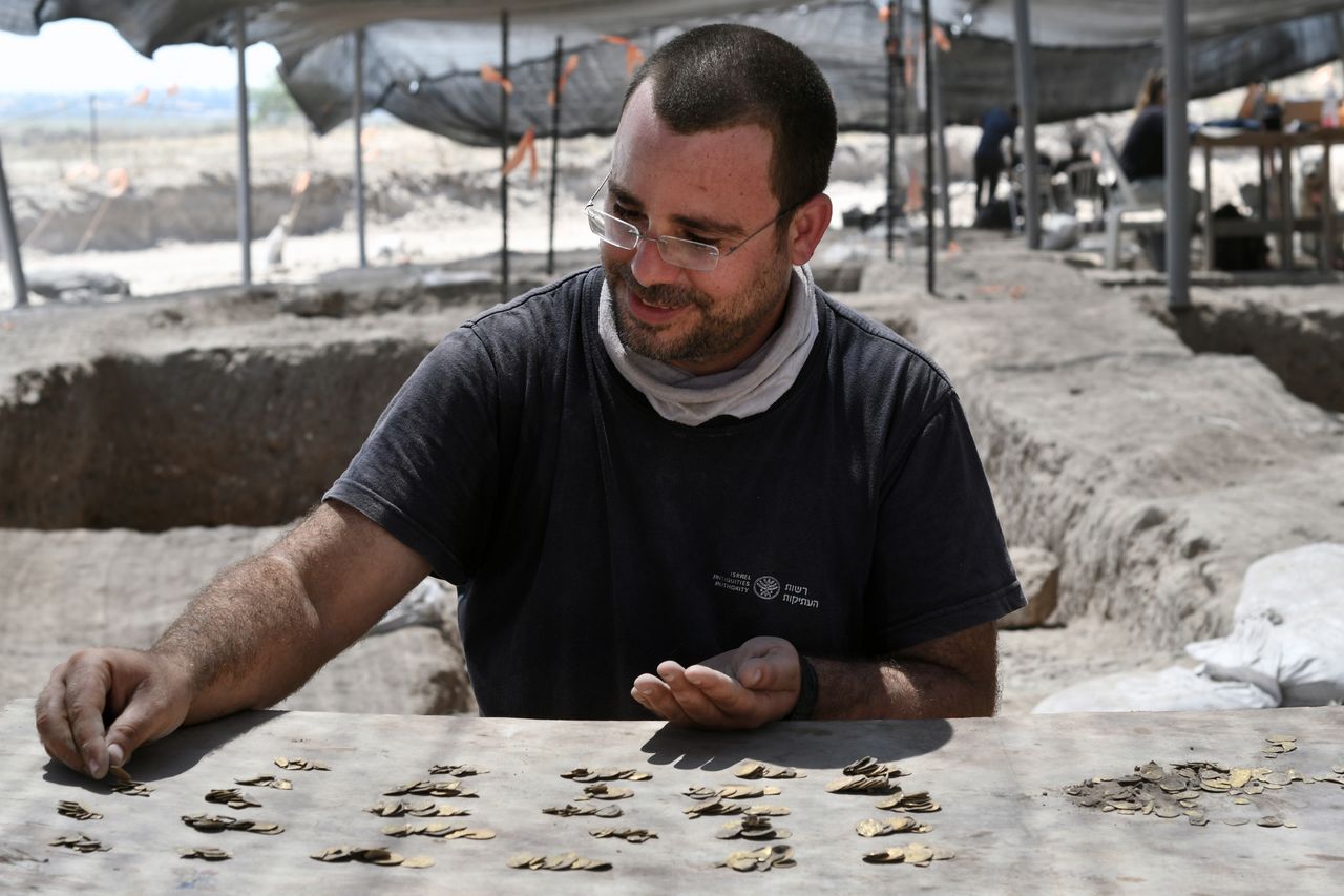 Shahar Krispin, Israel Antiquities Authority coin expert, counts the gold coins during the excavation.