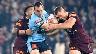 NSW Blues and QLD Maroons players tussle for the ball