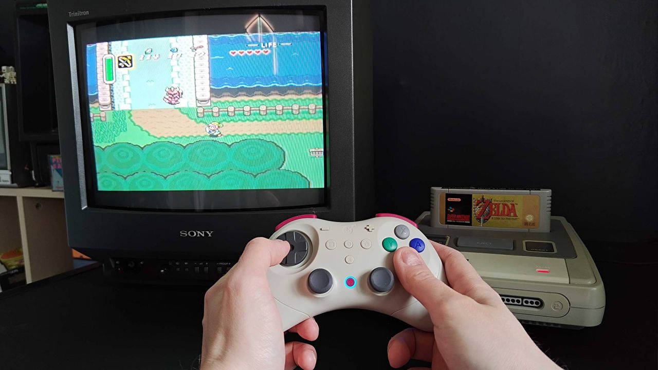 Hands using Gulikit Elves 2 Pro to play The Legend of Zelda: A Link to the Past on a SNES connected to a Sony Trinitron CRT TV.