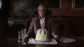   Jeremy Irons sits with an innocuous cake 
