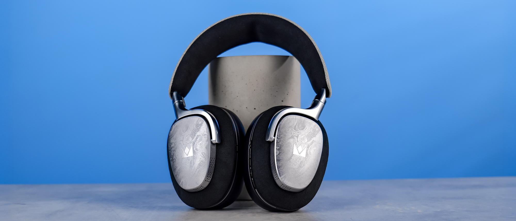 The Noble Audio FoKus Artemis on a stone surface, propped up on a plinth, against a blue background