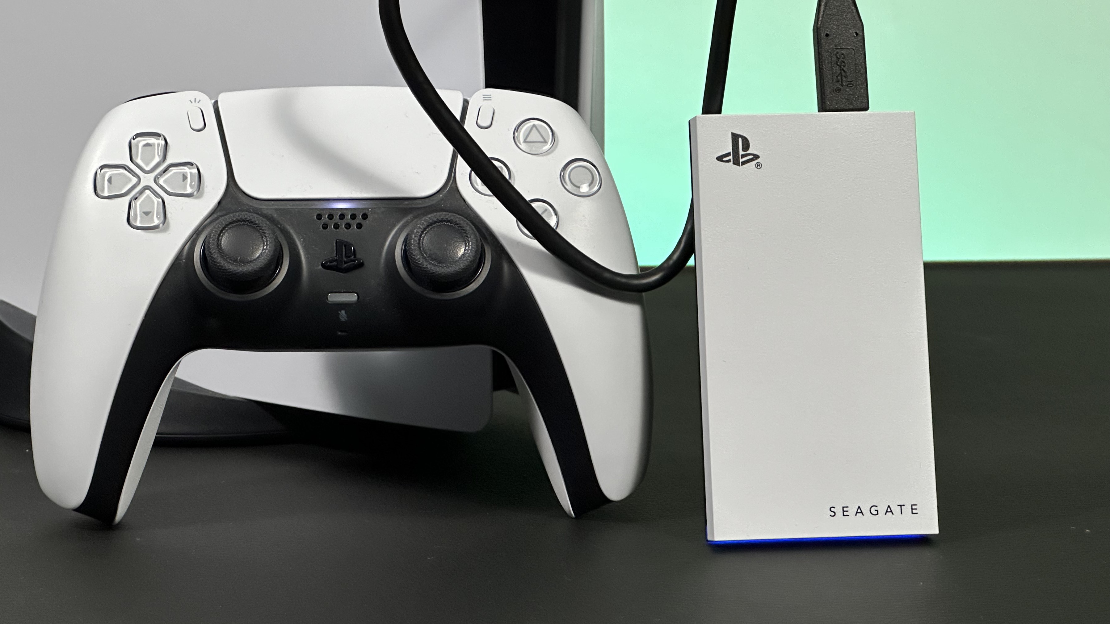 The Seagate Game Drive External SSD next to a PS5 and DualSense controller on a black desk